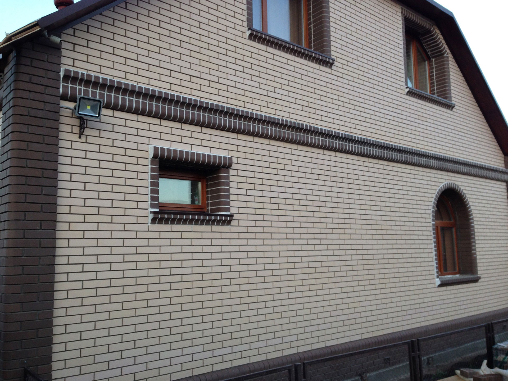Фасад дома облицованный лицевым керамическим кирпичом белого и коричневого цвета производства Старооскольского кирпичного завода